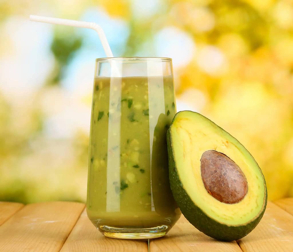 avocado fruit and avocado smoothie with straw